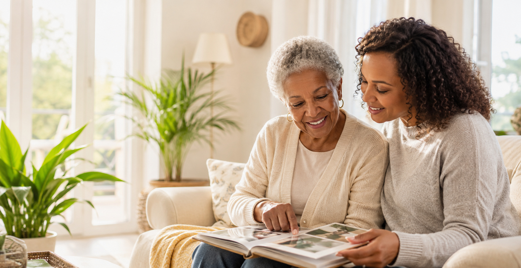 Older woman and her adult daughter looking through a family photo album at home